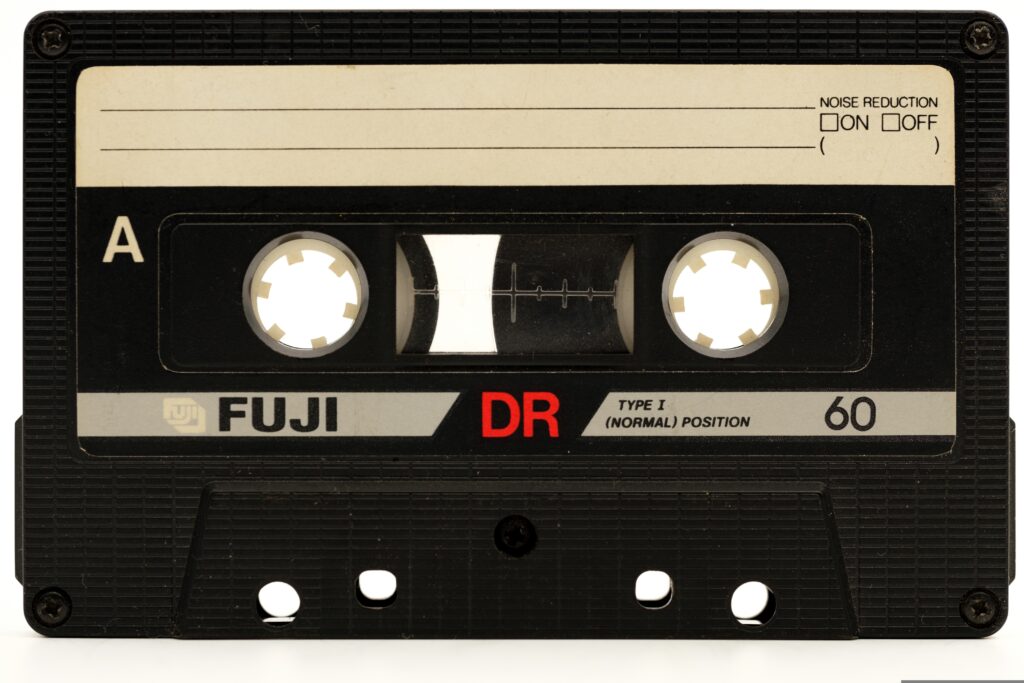 Černá kazeta s magnetofonovou páskou FUJI označená "DR" a stopáží "60."