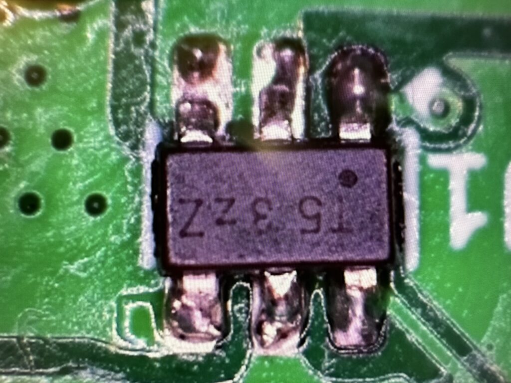 Detail plošného spoje pod zvětšovadlem, pohled na stabilizátor napětí.