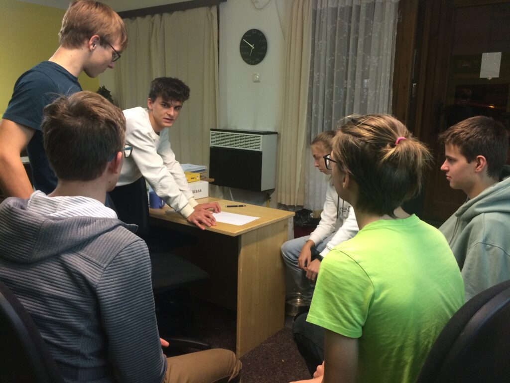 Skupina studentů dává pozor, co vysvětluje starší student