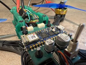 Zelená deska tištěných spojů s elektronickými součástkami a Arduinem Nano namontovaná na dronu.