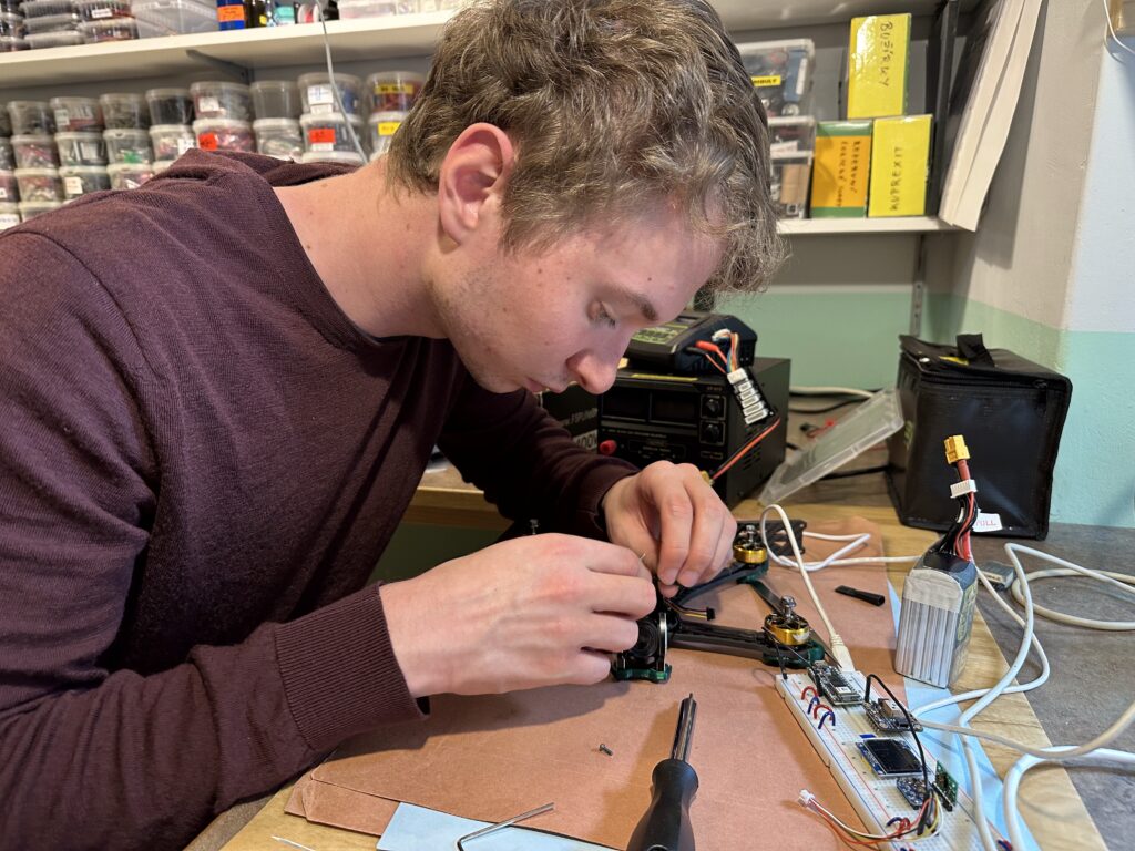 Filip montuje přední část svého FPV dronu.