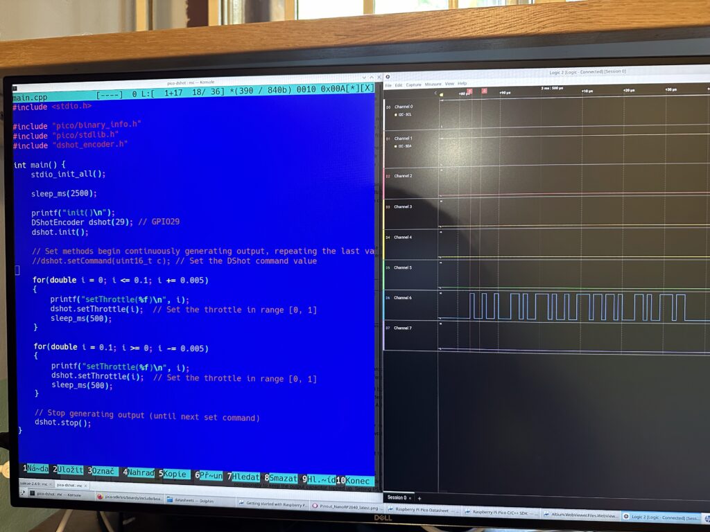 Počítačový monitor zobrazující editor s C++ s programem na nastavování rychlosti mmotoru pro Pico a logickým analyzátorem s tvarem průběhu DSHOT komunikace.